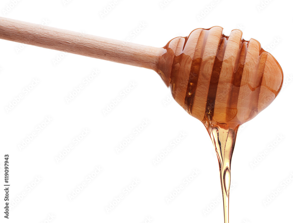 Honey dripping from a wooden honey dipper isolated on white back Honey dripping from a wooden honey dipper isolated on white back