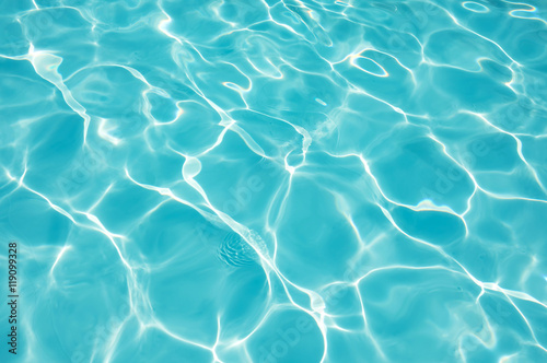 Water surface in swimming pool with sun reflection