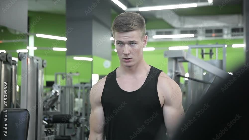 The man raises the bar in the gym The man raises the bar in the gym