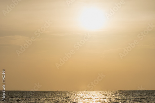 beautiful sunset on sea beach twilight time with warm weather and golden yellow sky