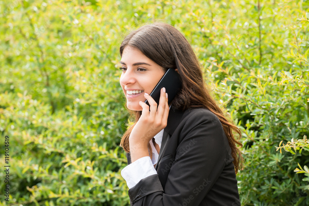Businesswoman Sitting On Bench Talking On Mobile Phone Businesswoman Sitting On Bench Talking On Mobile Phone