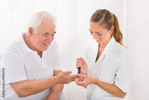 Doctor Using Lancelet On Patient's Finger