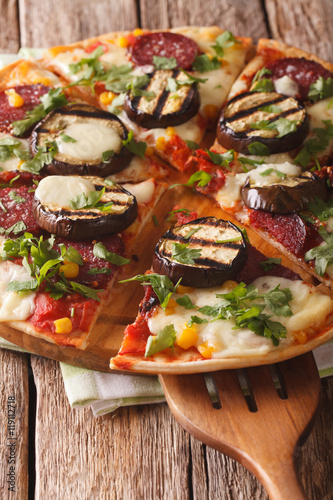 pizza with eggplant, salami, corn and mozzarella close up. vertical
