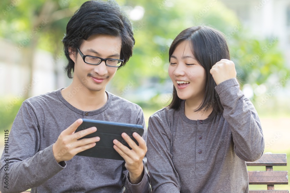 Couple Use Tablet at Park Couple Use Tablet at Park