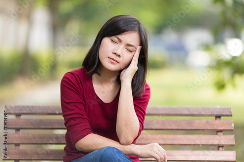 Woman Has Head Ache Sitting on Bench at Park