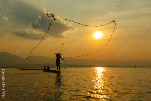 Fisherman , Silhouette fisherman with net at the lake in Thailand (kwan phayao) Phayao.-May 14,2016 photo