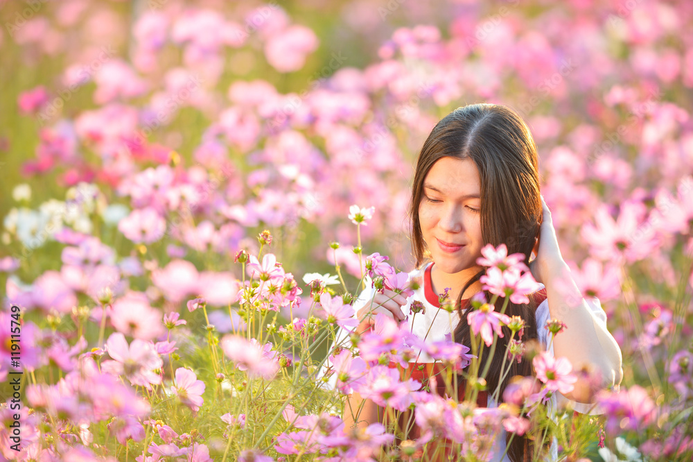 Woman and Cosmos flowers blooming in the garden Woman and Cosmos flowers blooming in the garden