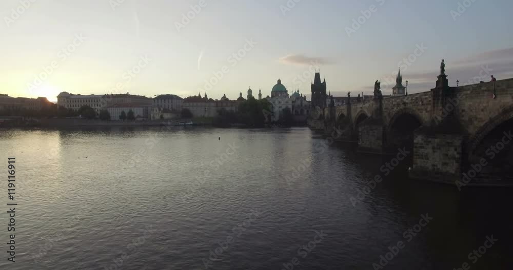 Aerial camera rises slowly beside the Charles Bridge in Prague to reveal the old city. Shot at sunrise Aerial camera rises slowly beside the Charles Bridge in Prague to reveal the old city. Shot at sunrise