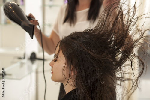 young woman in a hair salon. drying hair with hair dryer