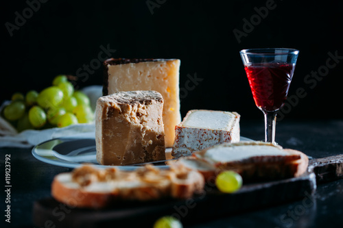 Closeup of cheese on plate and a red wine photo