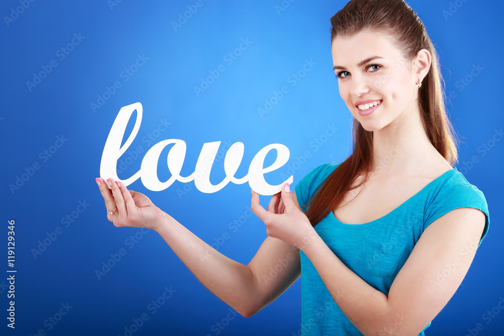 Beautiful young woman with a sign the word: love Beautiful young woman with a sign the word: love