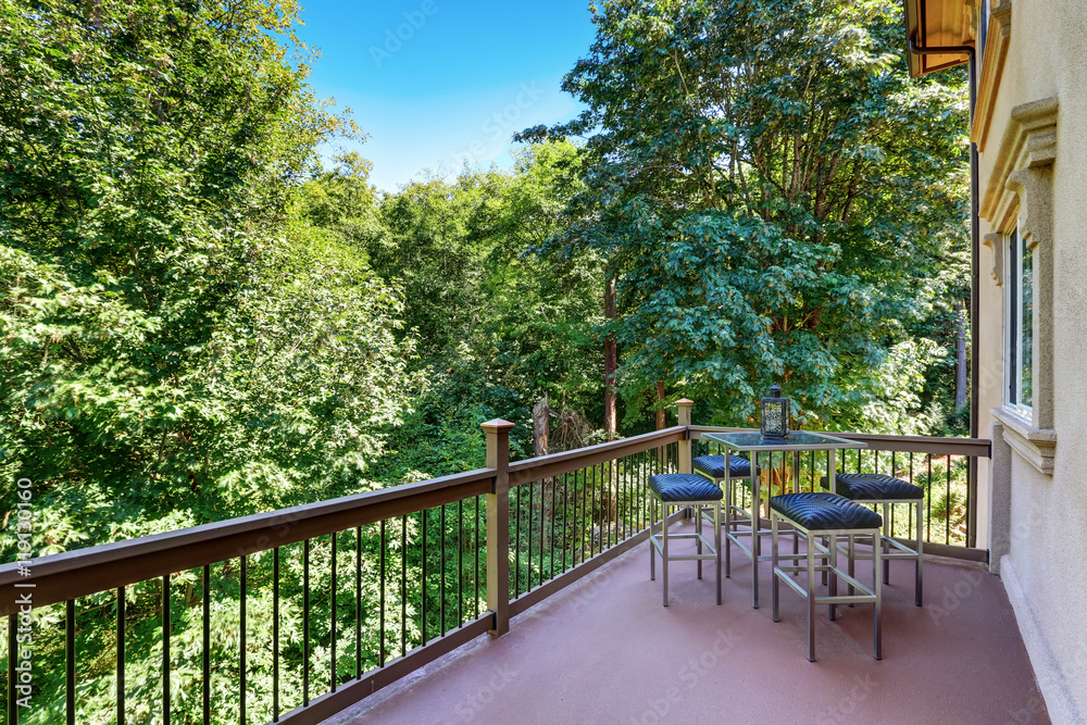 Second floor balcony with outdoor table and chair set Second floor balcony with outdoor table and chair set