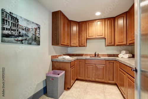 Laundry room with sink and wood cabinets.
