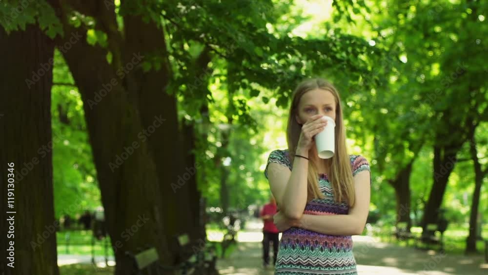 Happy girl walking with a coffee in the park and relaxing
Happy girl walking with a coffee in the park and relaxing