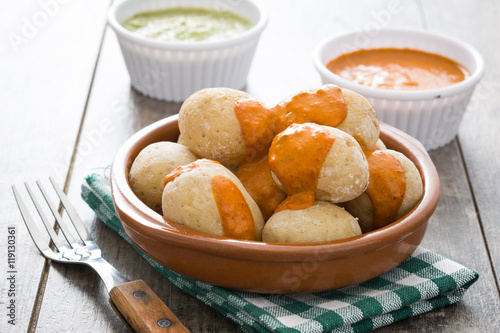 Canarian potatoes (papas arrugadas) with mojo sauce on wooden table


