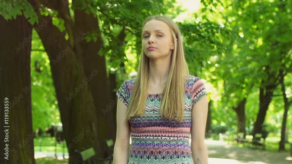 Pretty girl walking on pathway in the park and looking to the camera
Pretty girl walking on pathway in the park and looking to the camera