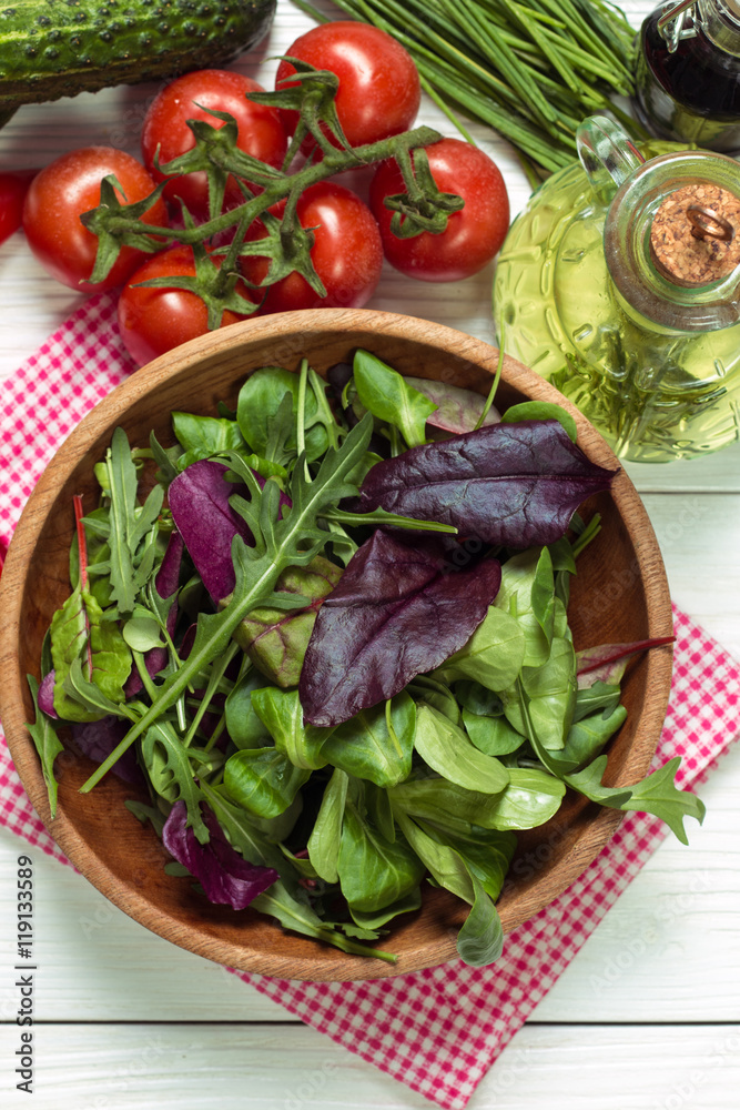 Fresh green salad with spinach ,ruccola,lettuce on wooden table.
