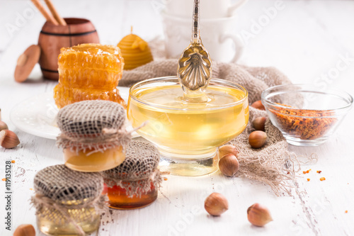 jar of honey with honeycomb on wooden table