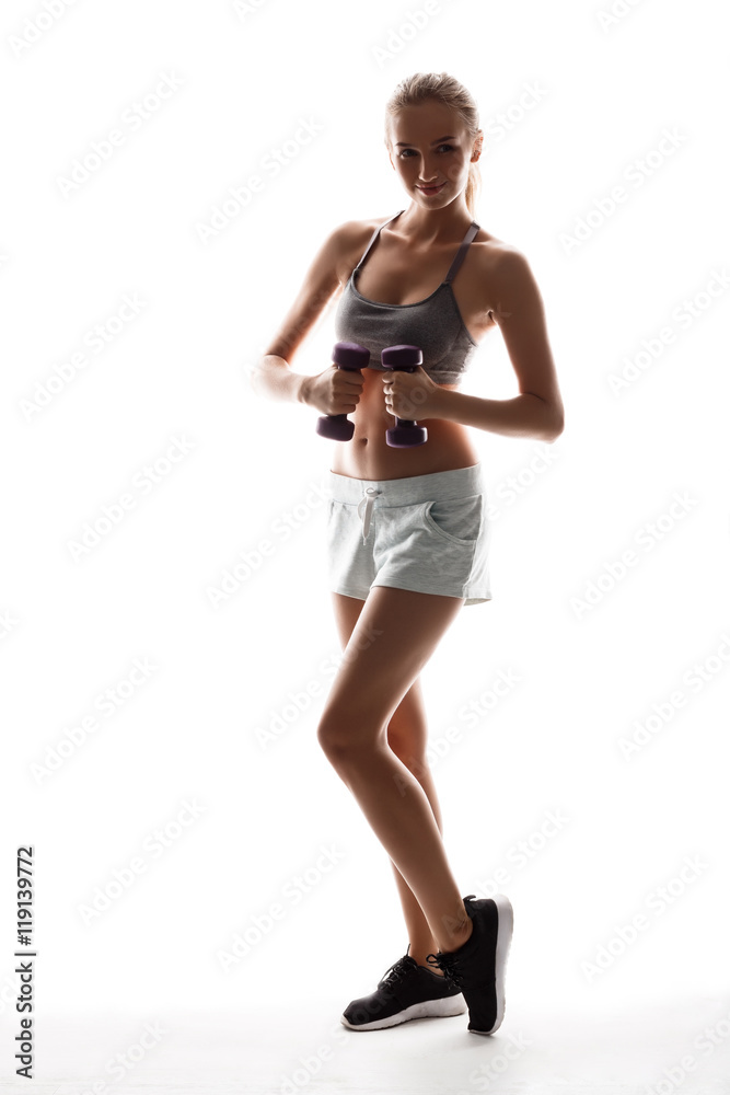 Beautiful sportive girl training with dumbbells over white background. Beautiful sportive girl training with dumbbells over white background.