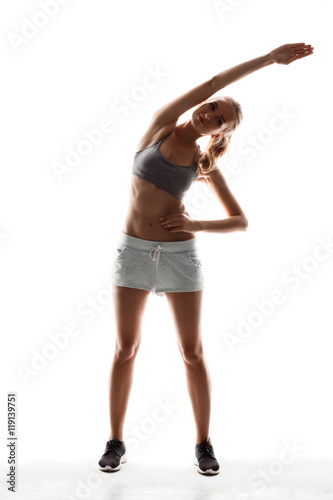 Beautiful sportive girl training over white background.