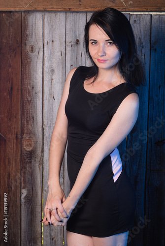 Beautiful girl in evening dress, the model poses against a wooden wall, © vulkanov
