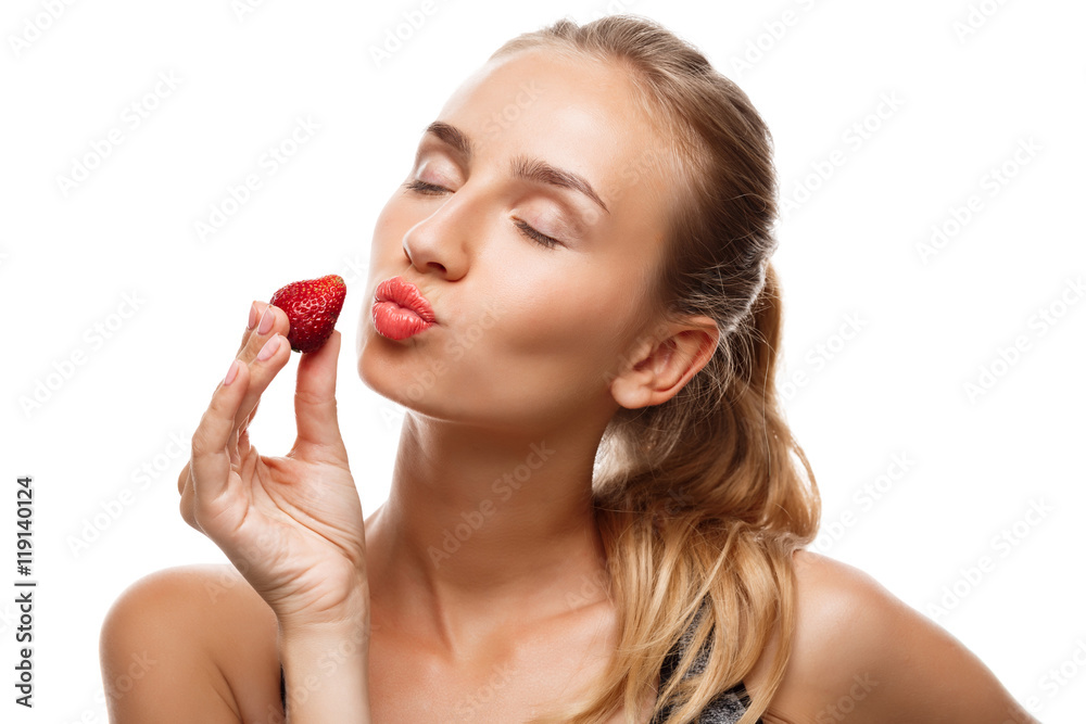 Beautiful sportive girl posing, eating strawberry over white background. Beautiful sportive girl posing, eating strawberry over white background.