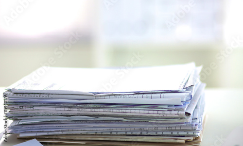 stack of papers on the desk with computer