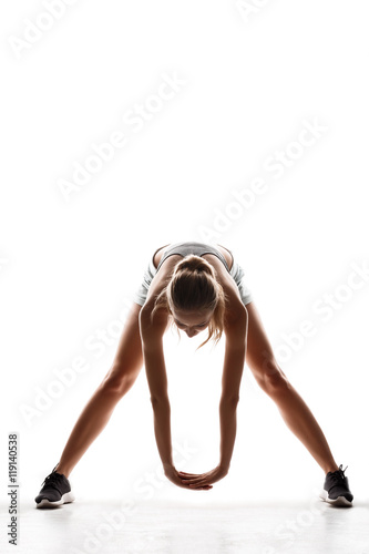 Beautiful sportive girl training over white background.