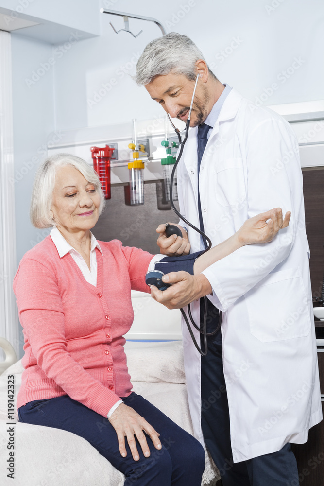 Obraz premium Doctor Checking Blood Pressure Of Senior Patient In Rehab Center