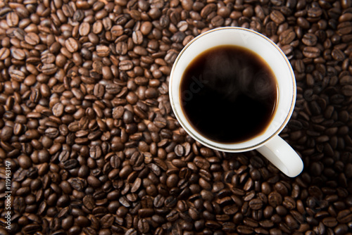 White coffee cup on coffee seeds background