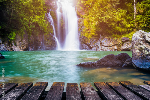Canvas Print Waterfall in deep forest and wood pier for background