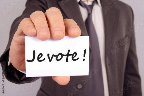 Homme tenant une carte avec écrit dessus je vote