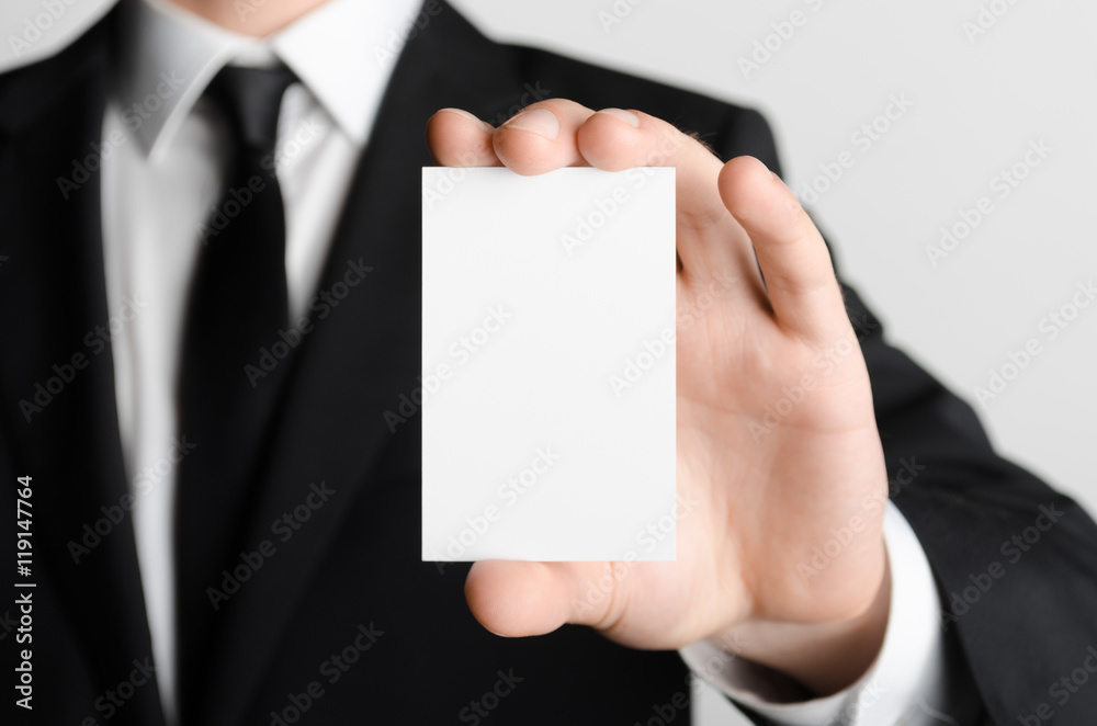 Business Card Mock-Up (85x55mm) - Man in a black suit holding a blank card on a gray background. Business Card Mock-Up (85x55mm) - Man in a black suit holding a blank card on a gray background.