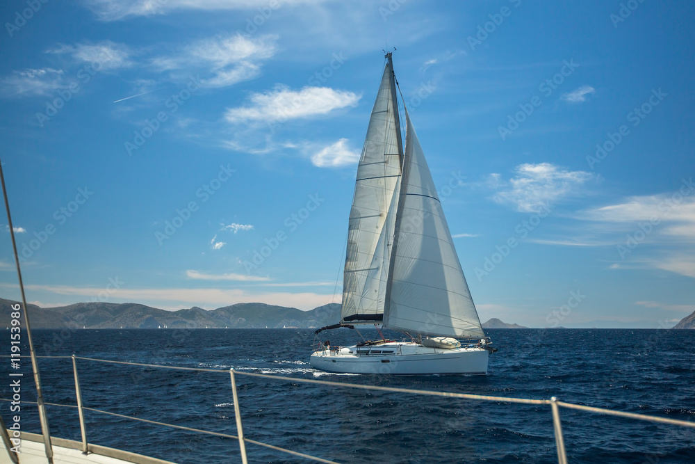 Obraz premium Sailing boats on the waves of the Aegean sea. Yachting in Greece. Luxury Yachts.
