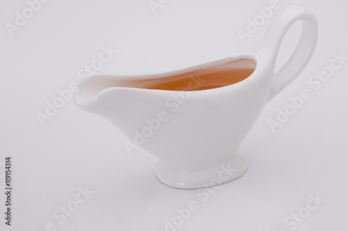 sauce in white gravy boat on a white background
