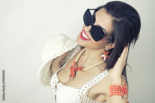 Woman smiling with perfect smile wearing sunslusses and jewelry photo