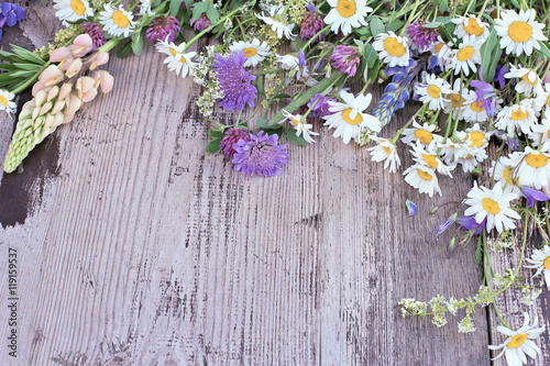 Various wild flowers 
on wooden background 