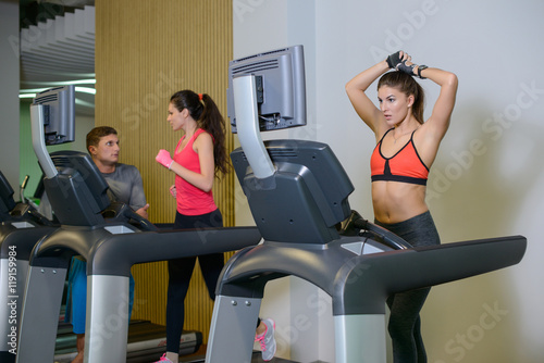 fitness girl on the treadmill with a trainer