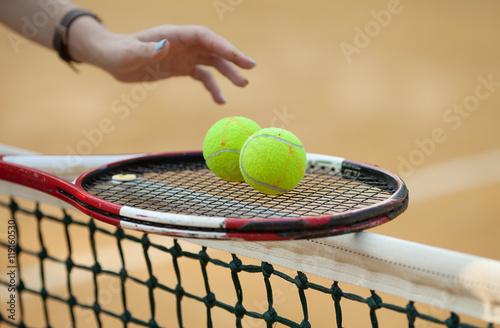tennis racket with ball on clay court