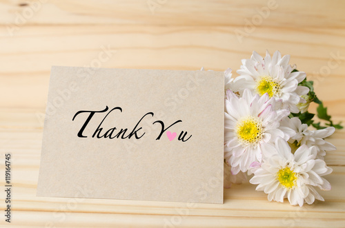 White chrysanthemum flowers with thank you card on wooden backgr