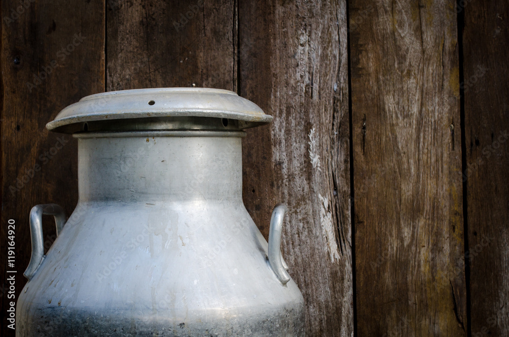 Old metal can on milk on wooden background Old metal can on milk on wooden background