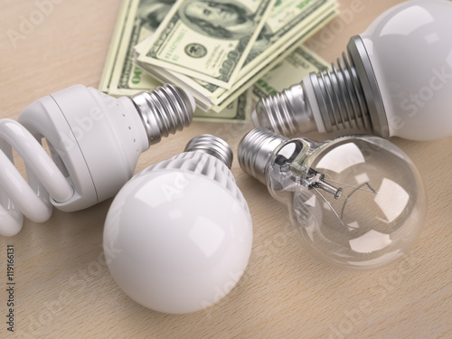 Light bulbs in front of dollar bill stack