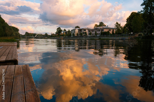 August 23, 2016 Emajogi river in residential area of Tartu, Estonia. Beautiful sunset clouds reflect in the water. 