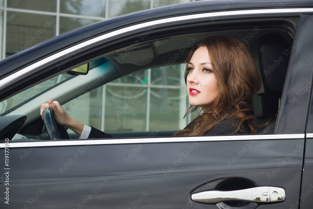 Young confident businesswoman driving car