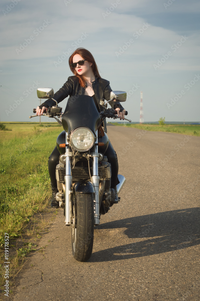 Obraz premium Biker girl in a leather jacket on a motorcycle