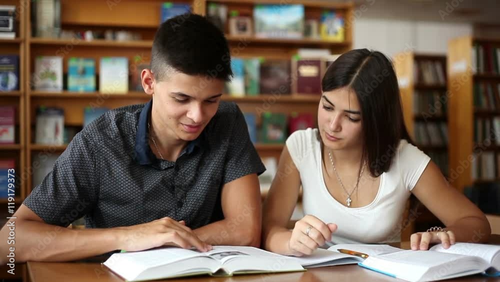 students are ridding books in a library students are ridding books in a library