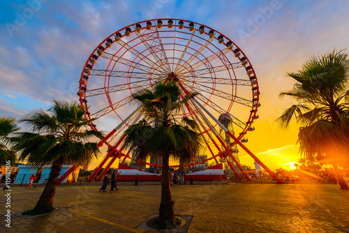 Ferris wheel on amazing sunset sky background