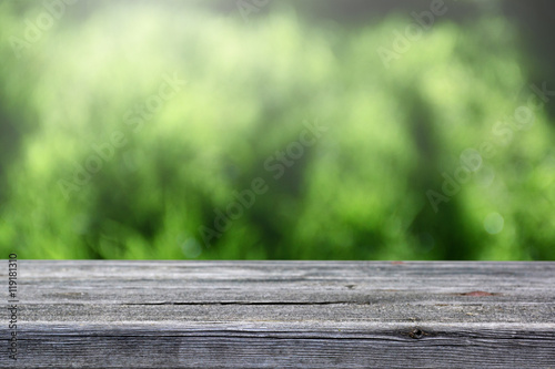 Soft blur wooden table and defocused green background.