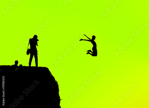 Silhouette of a man jumping off a cliff on a green background