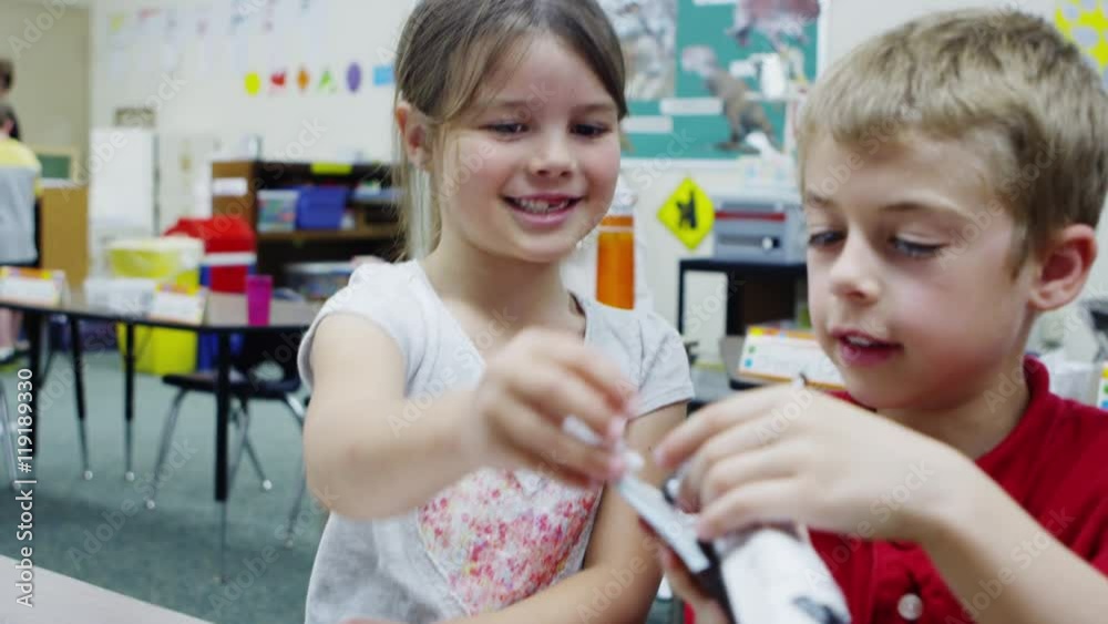 Boy and girl playing with toy shuttle in class Boy and girl playing with toy shuttle in class